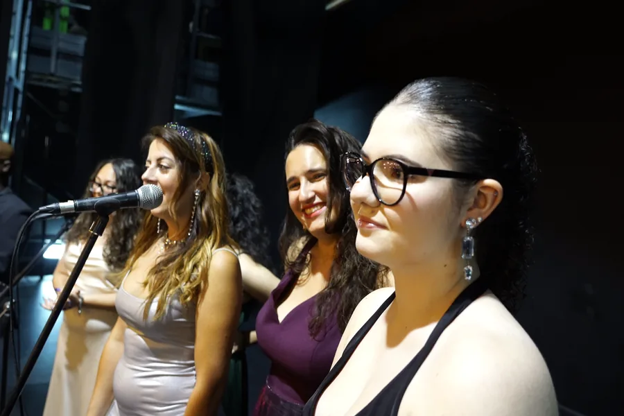 Las cuatro coristas de Soul & Silence cantando ante el micrófono durante el ensayo.
